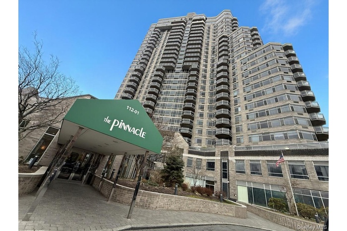 High-rise building with a stone facade and multiple levels of individual balconies