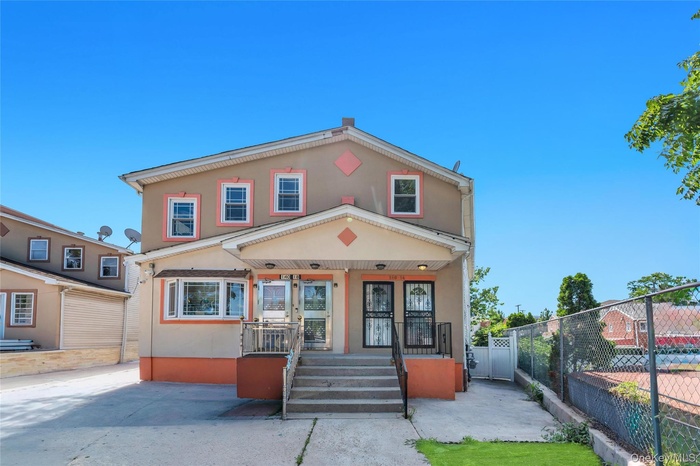 Two-story exterior with a covered porch, multiple windows, and a paved driveway