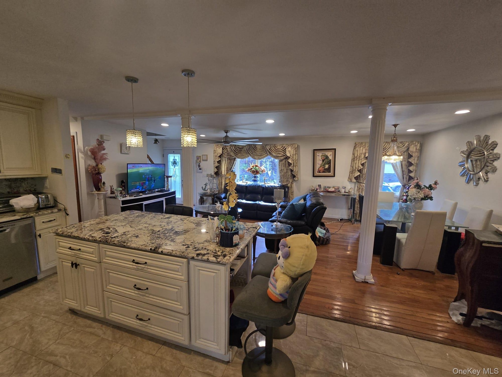 Kitchen island featuring a patterned countertop with pendant lighting, integrated cabinetry, and tiled flooring