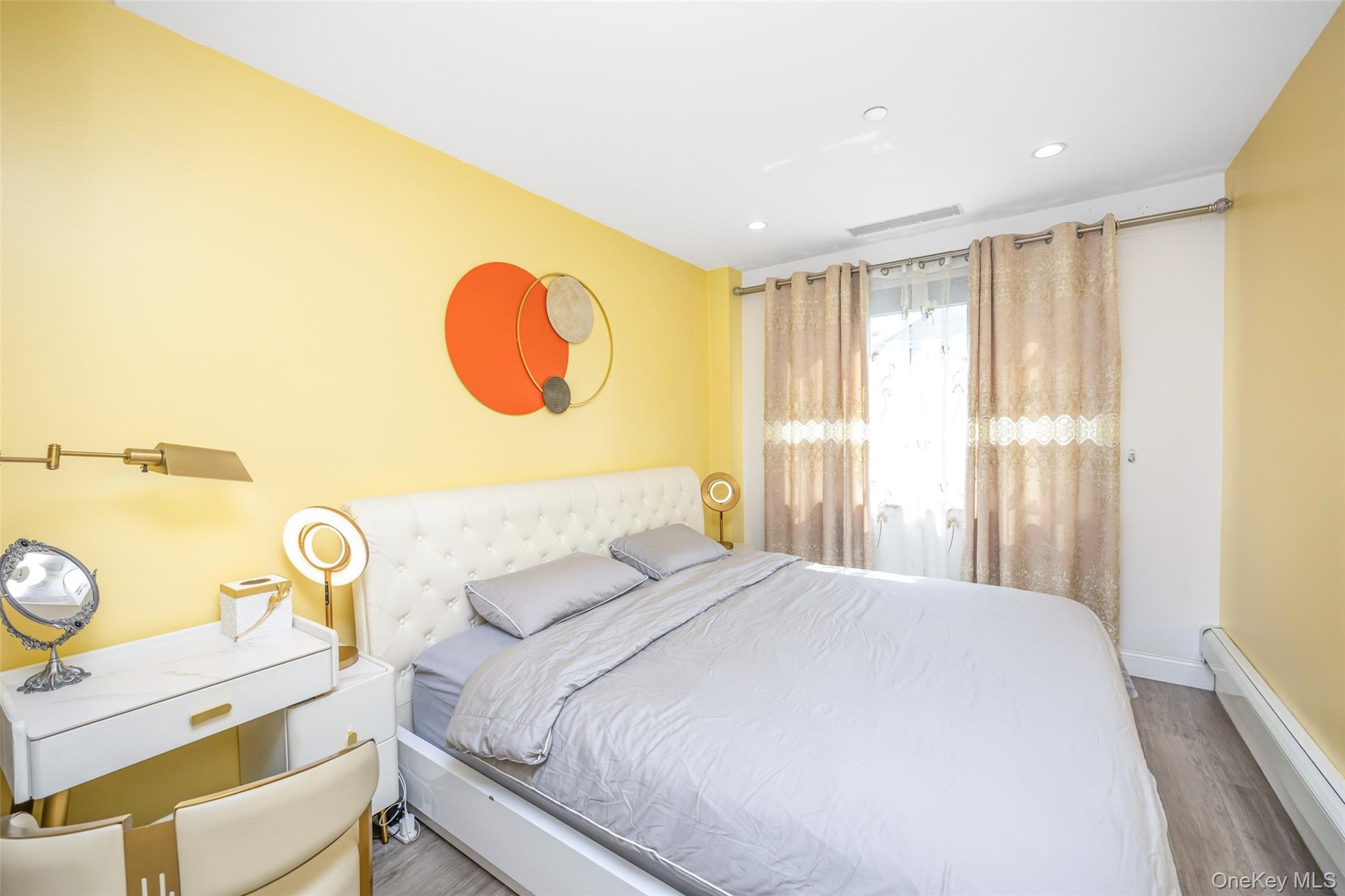 Bedroom featuring a baseboard heating unit, recessed lighting, and wood finished floors