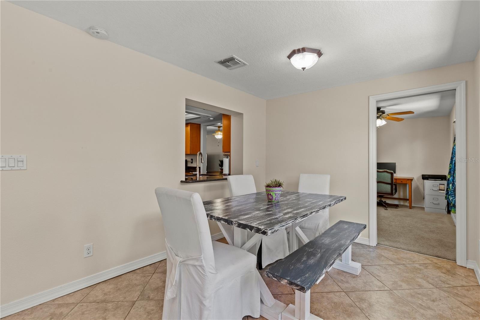 Bright Florida room offering flexible living space and convenient access to the fourth bedroom, making it ideal for use as a home office, guest suite,