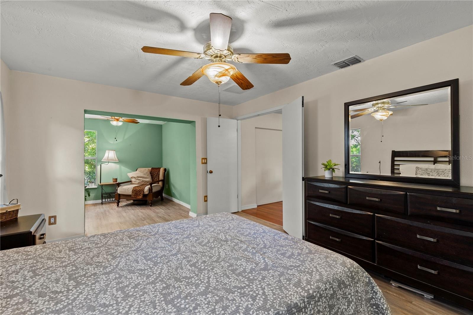 Spacious primary bedroom retreat featuring a bright and airy layout with a comfortable sitting area, creating the perfect space for relaxation and pri