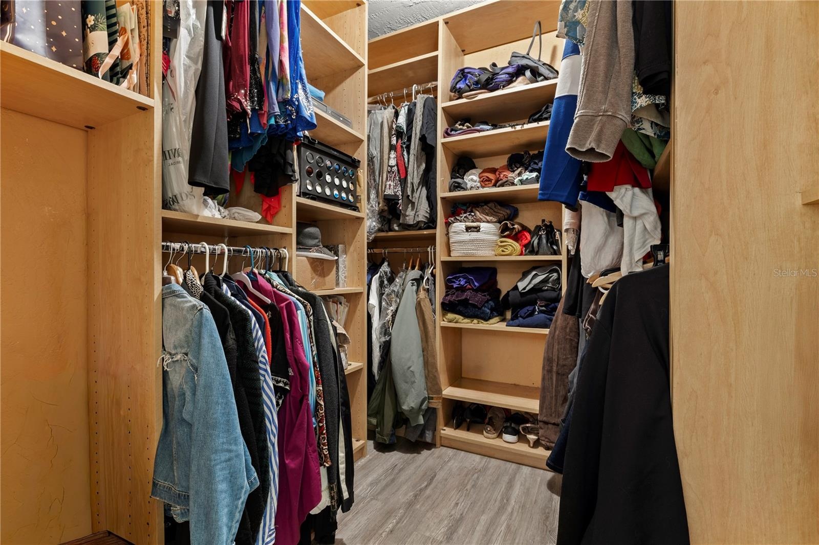 Primary walk in closet with organizer.