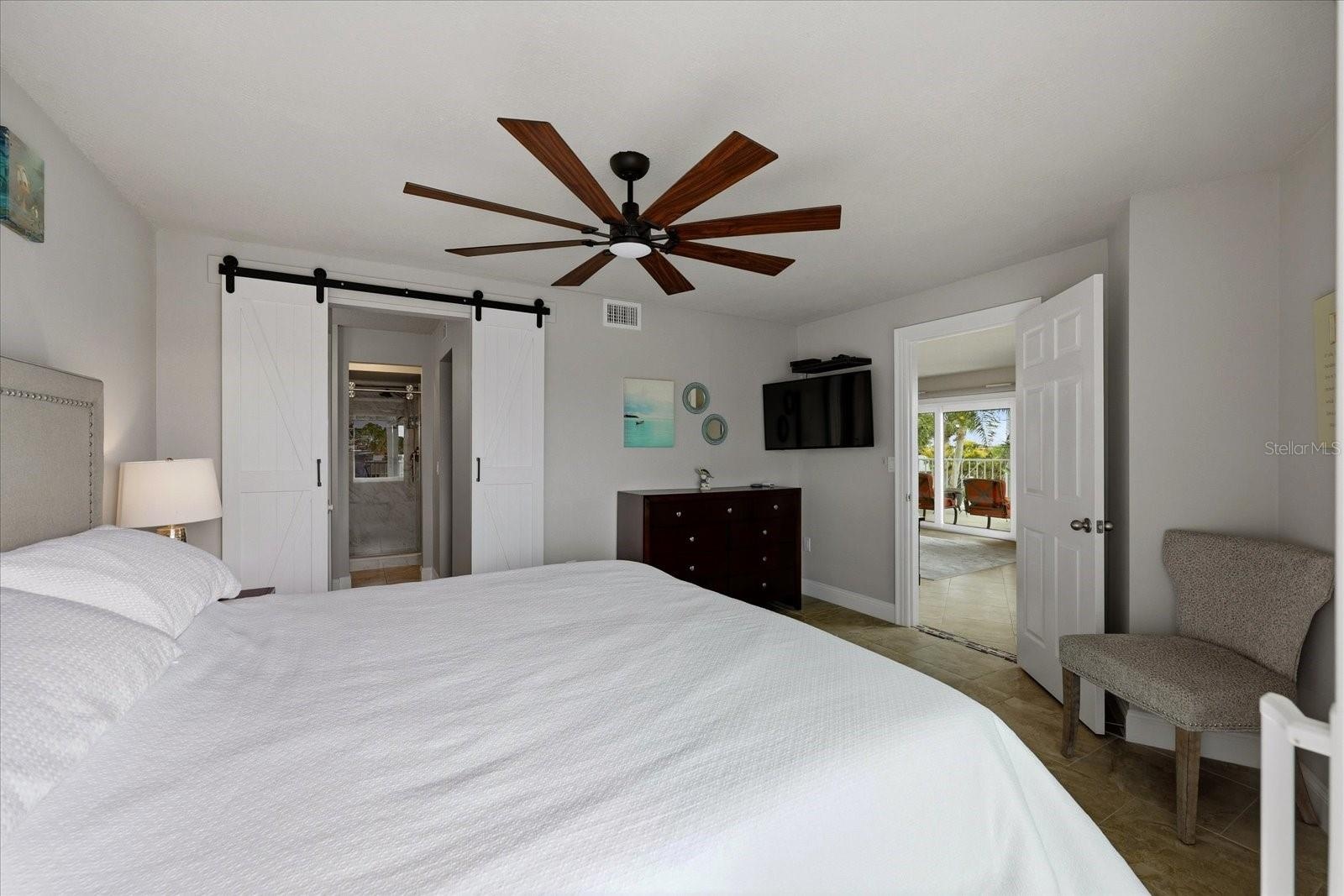 Barn doors leading to primary bathroom and closet