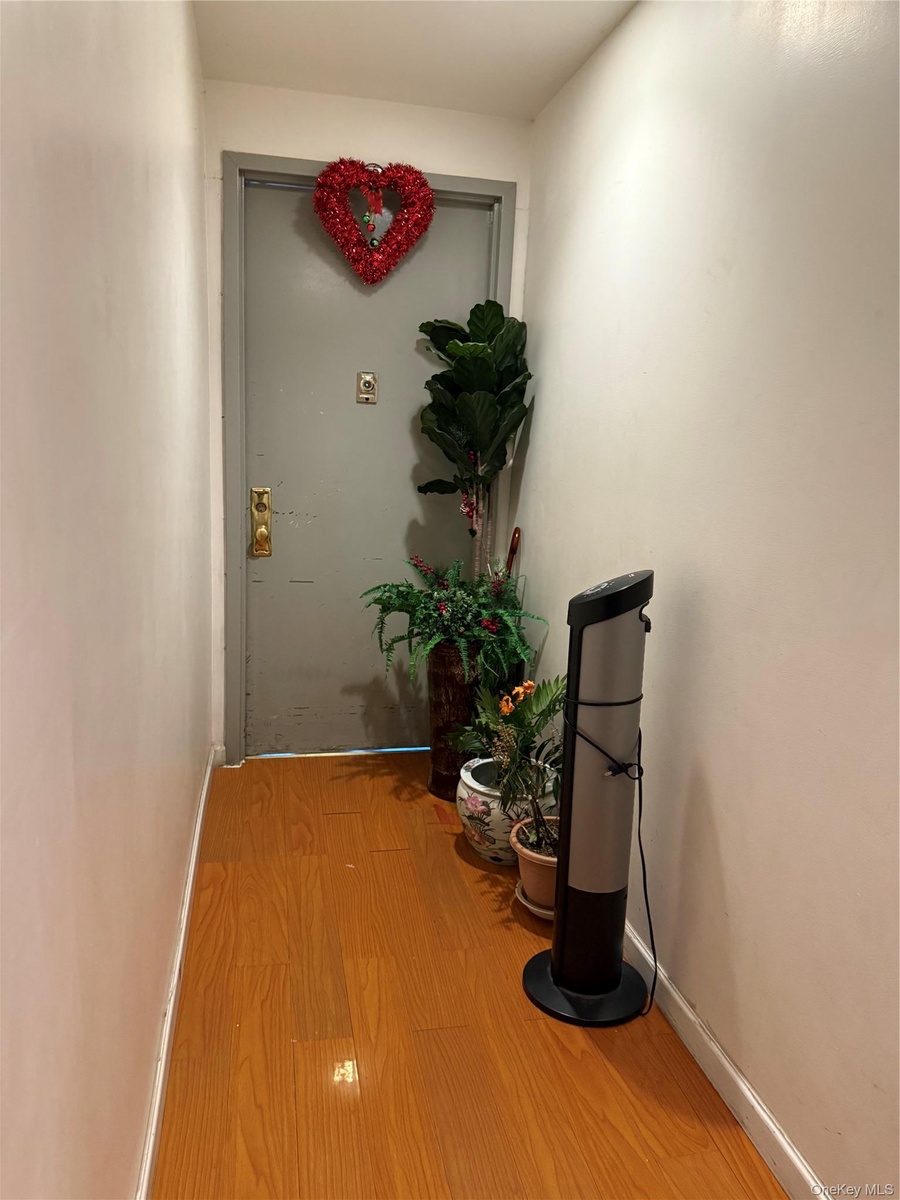 Hallway with hardwood / wood-style flooring