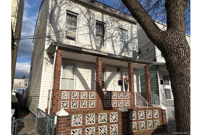 Two-story white siding residence featuring a covered front porch supported by brick pillars