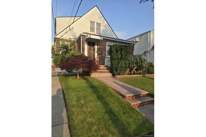 Brick and siding exterior featuring an arched awning above the entry
