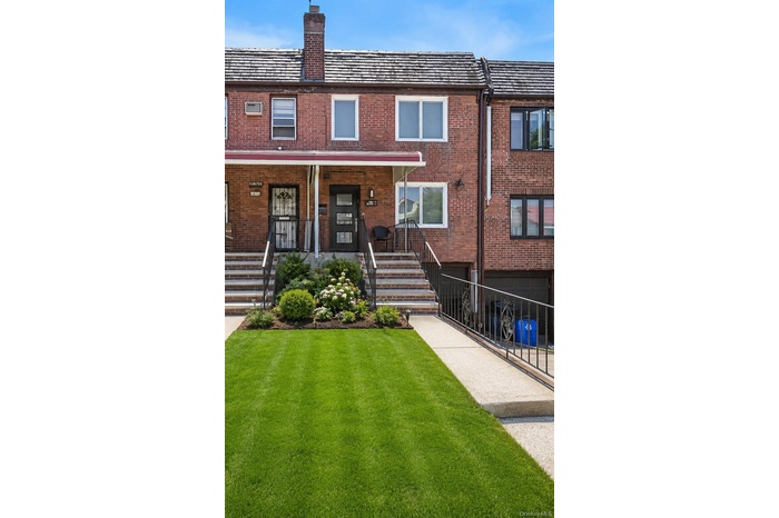 Brick facade home featuring a covered front porch, concrete front steps with metal railings, and a concrete driveway