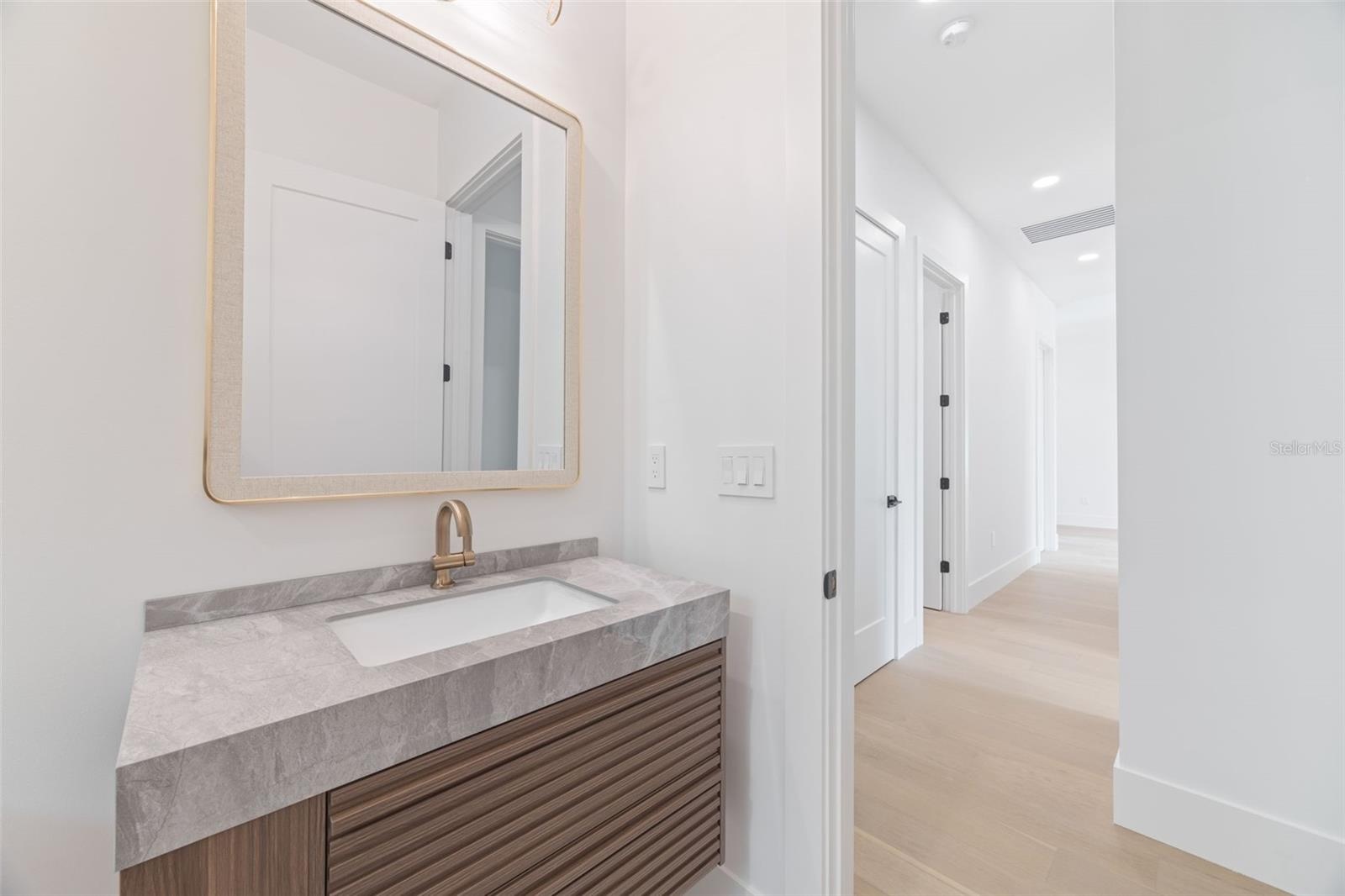 The 2nd full bathroom showcases oversized Italian tile, designer-selected fixtures, and elegant finishes consistent with the home's custom craftsmansh