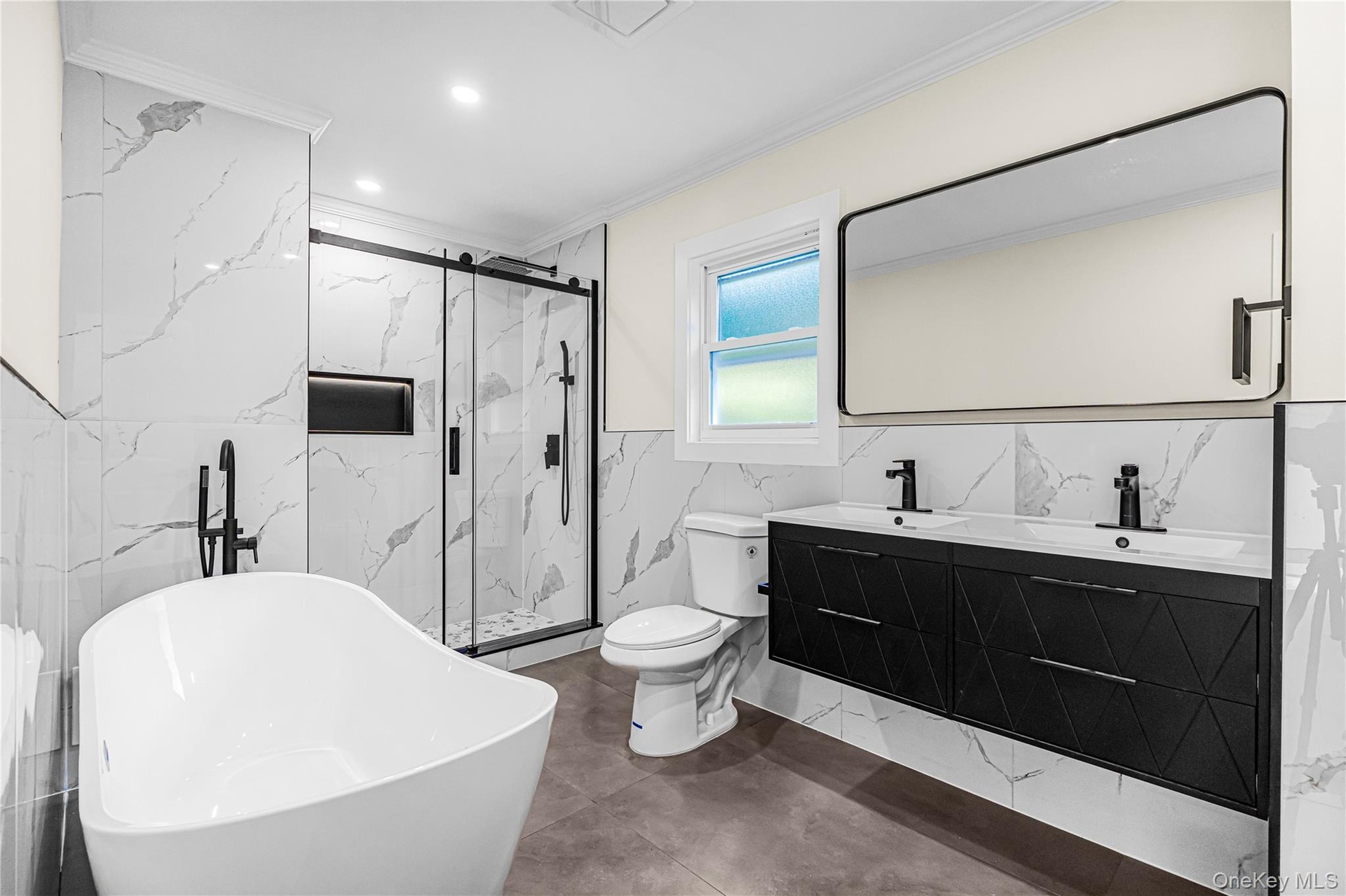 Contemporary bathroom featuring a freestanding tub with a matte black floor-mounted faucet, a double vanity with matte black fixtures, a walk-in showe