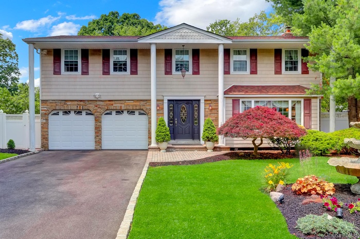 Large Colonial residence featuring a prominent front entrance with an ornate dark wood door