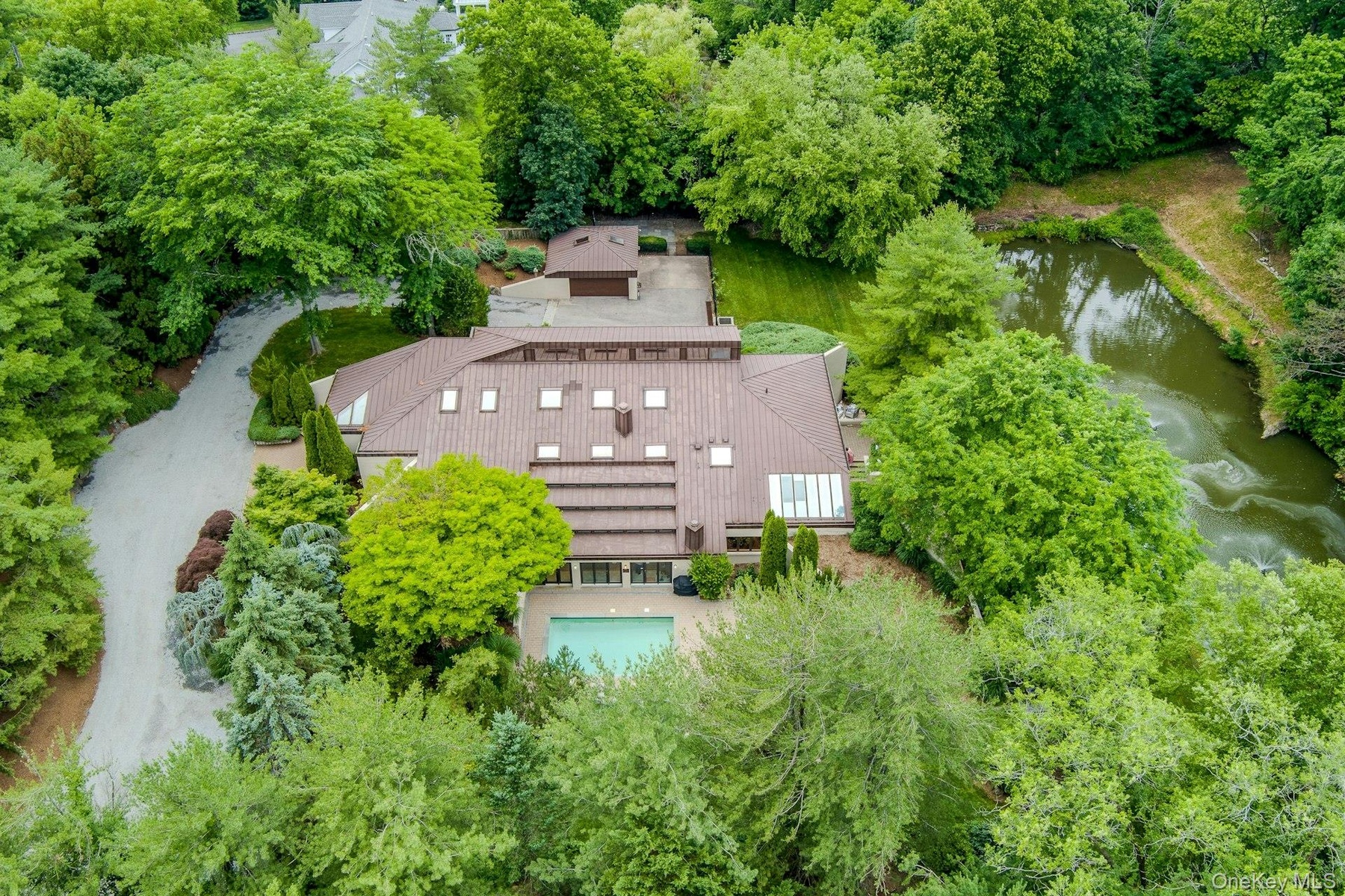 An aerial perspective showcases the home's distinctive contemporary architecture, resort-inspired amenities, and extraordinary two-acre setting.