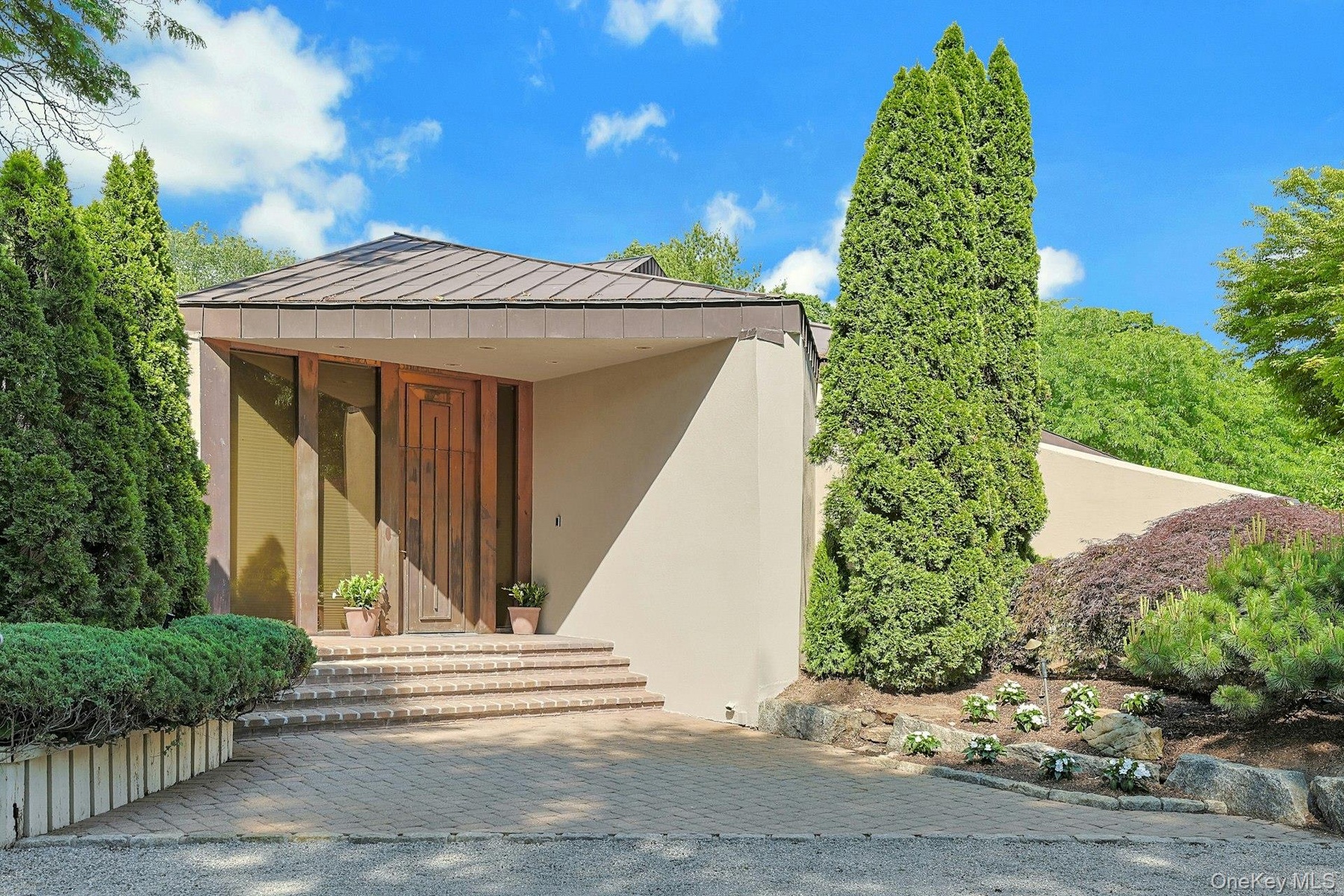 A dramatic copper entry door and striking architectural lines create a memorable first impression upon arrival.