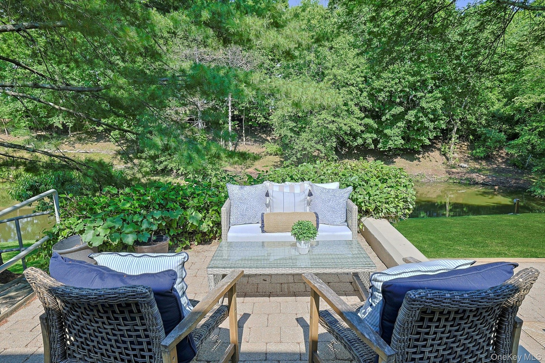An elevated terrace  off of the living room and overlooking the pond offers the perfect place to unwind and enjoy the peaceful setting.