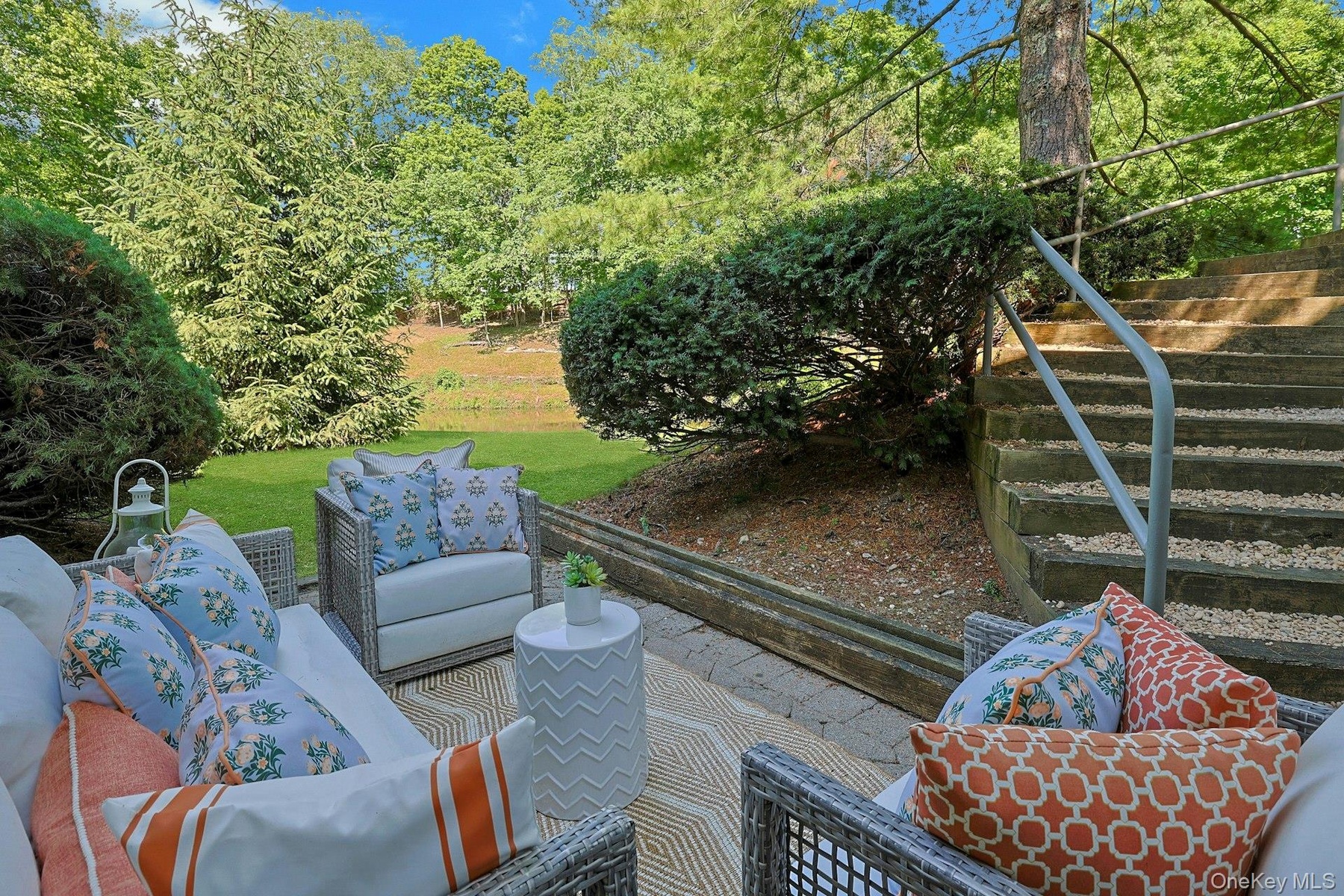 Tucked beneath a canopy of mature trees, this secluded patio off of the playroom creates a peaceful extension of the lower level and a quiet place to 