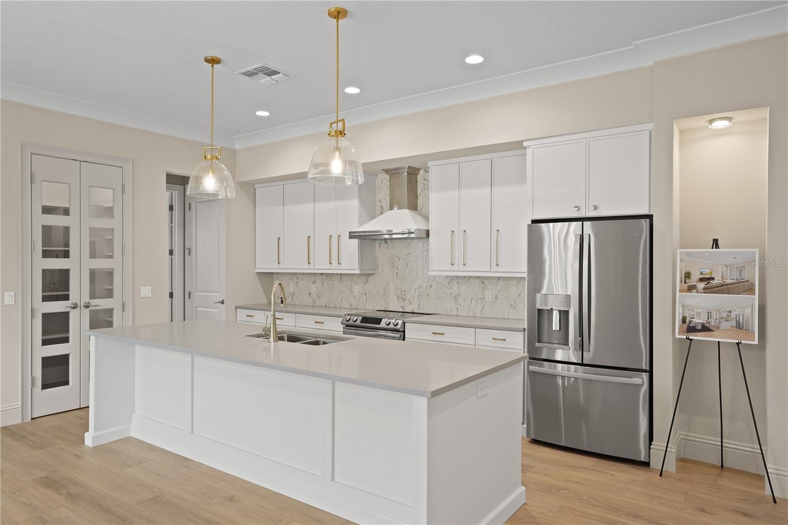 Gourmet kitchen is a chefs dream, centered around large island with sink and elegant pendant lighting.  Stainless steel appliance, extensive cabinety 
