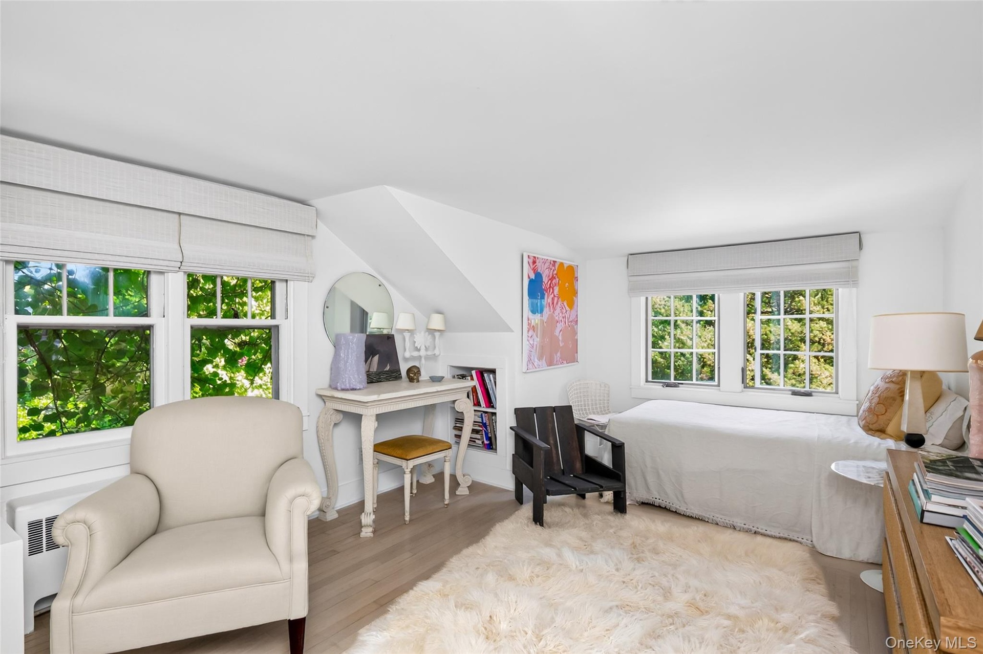 Bright interior featuring light wood-finish flooring, white walls, and multiple windows