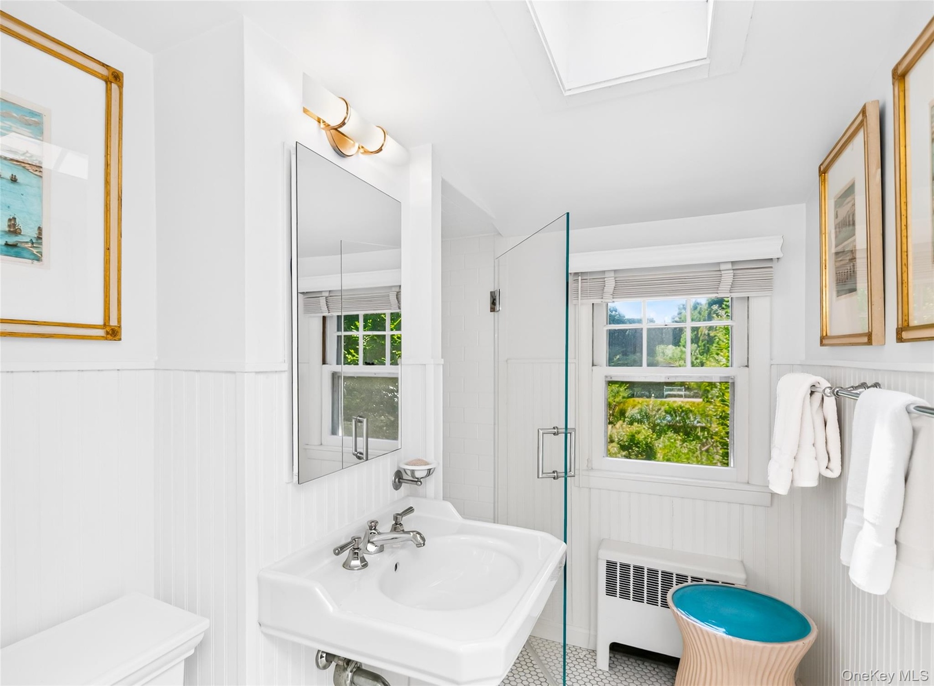 Bathroom featuring wainscoting and a pedestal sink with chrome fixtures