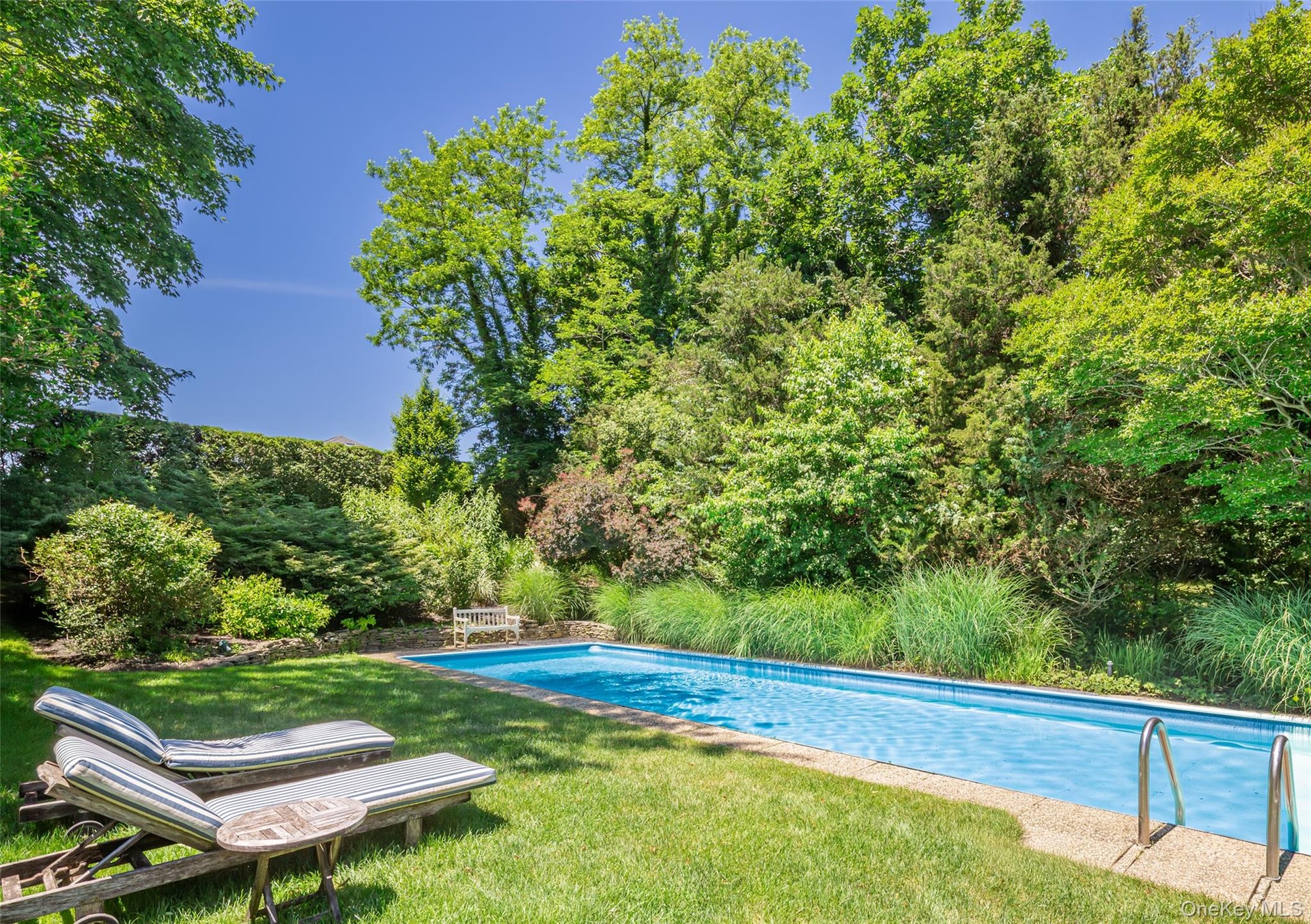 Rectangular in-ground swimming pool with a light blue interior finish and textured concrete coping