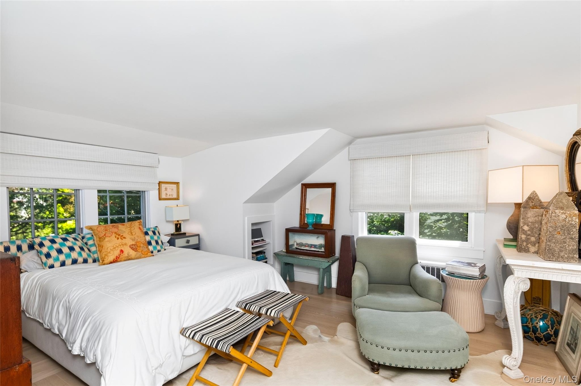 Bright interior featuring light wood-finish flooring and multiple windows with white blinds