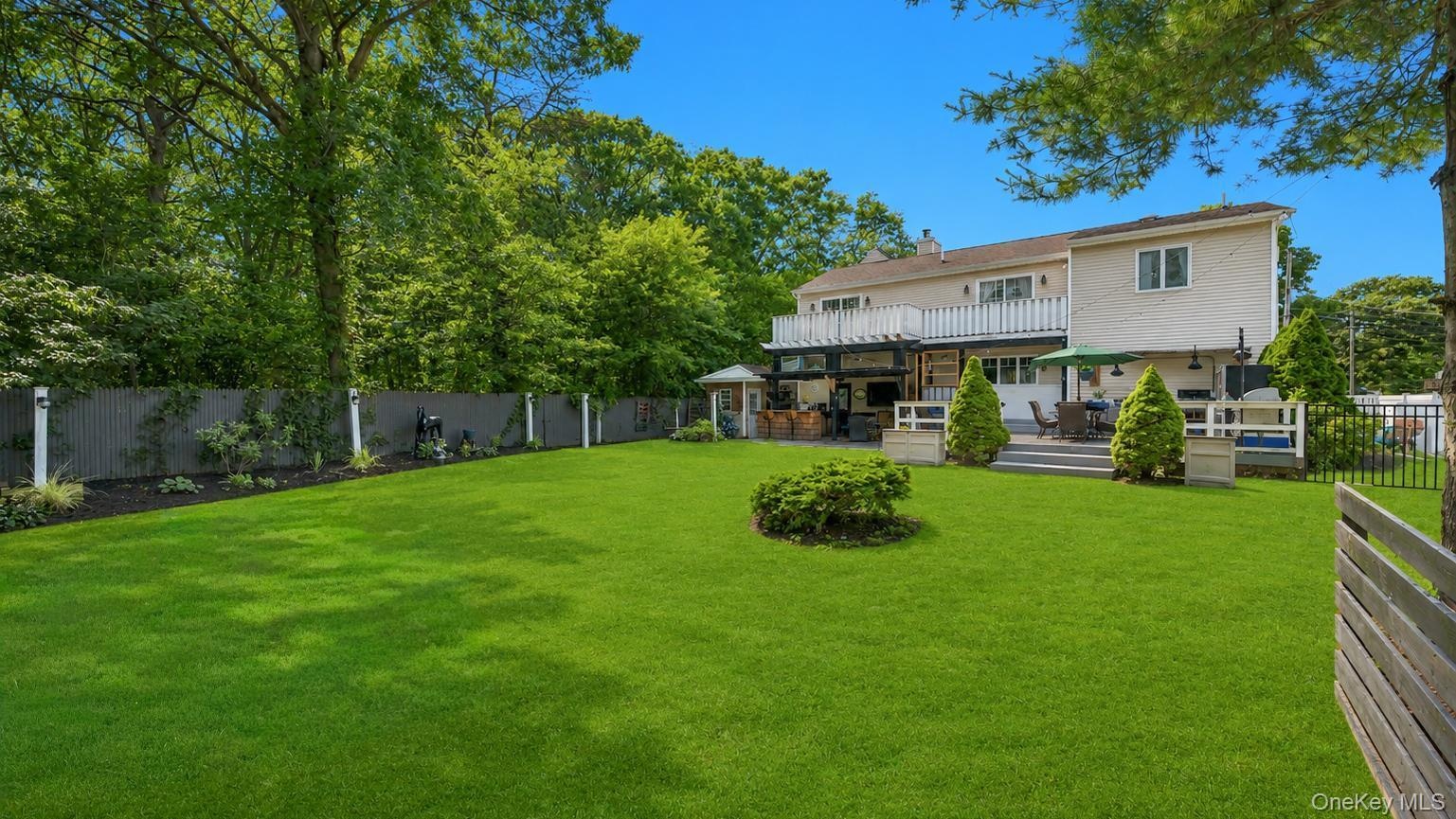 Expansive green lawn with mature perimeter trees