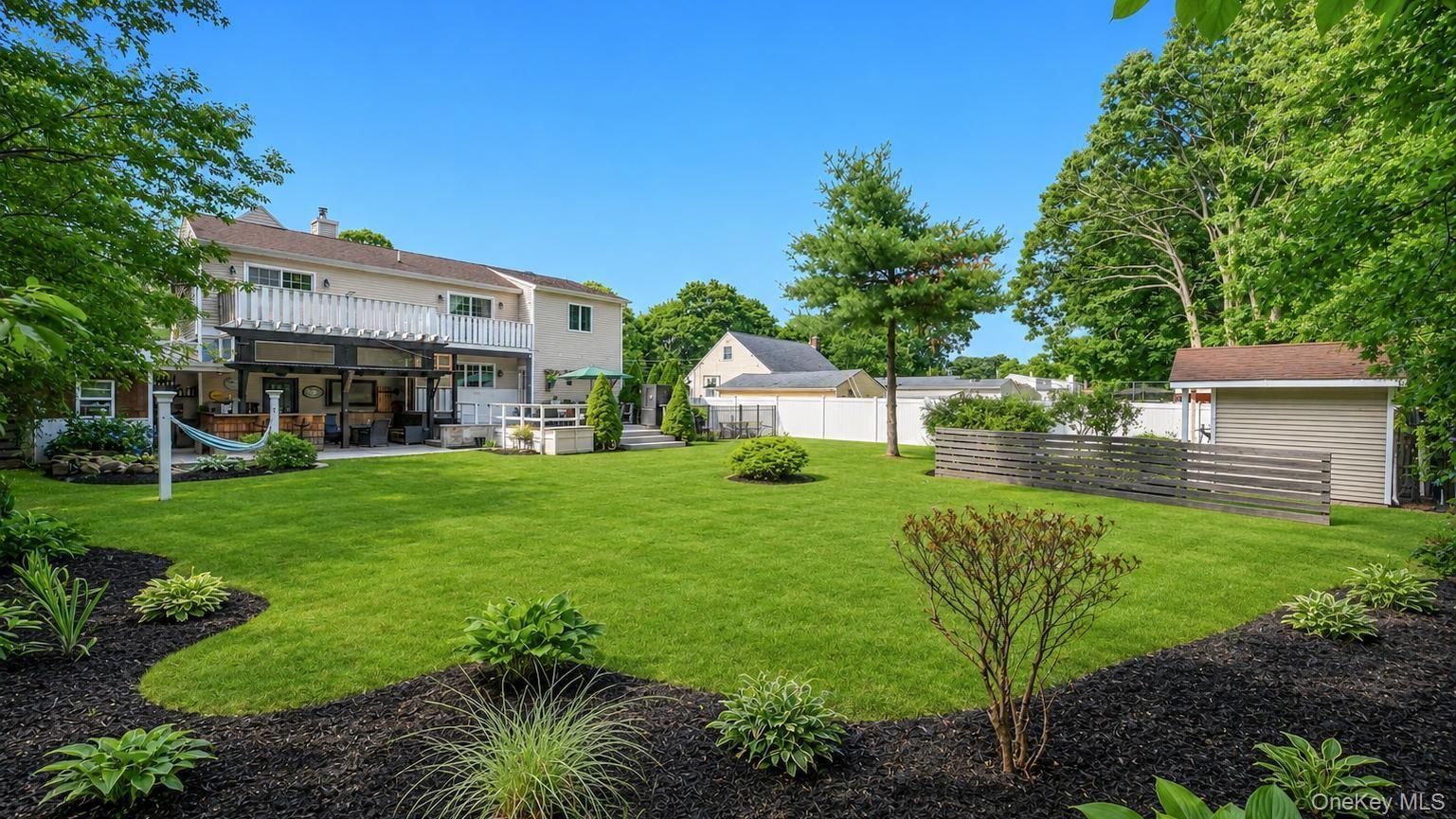 Expansive green lawn with mature perimeter trees