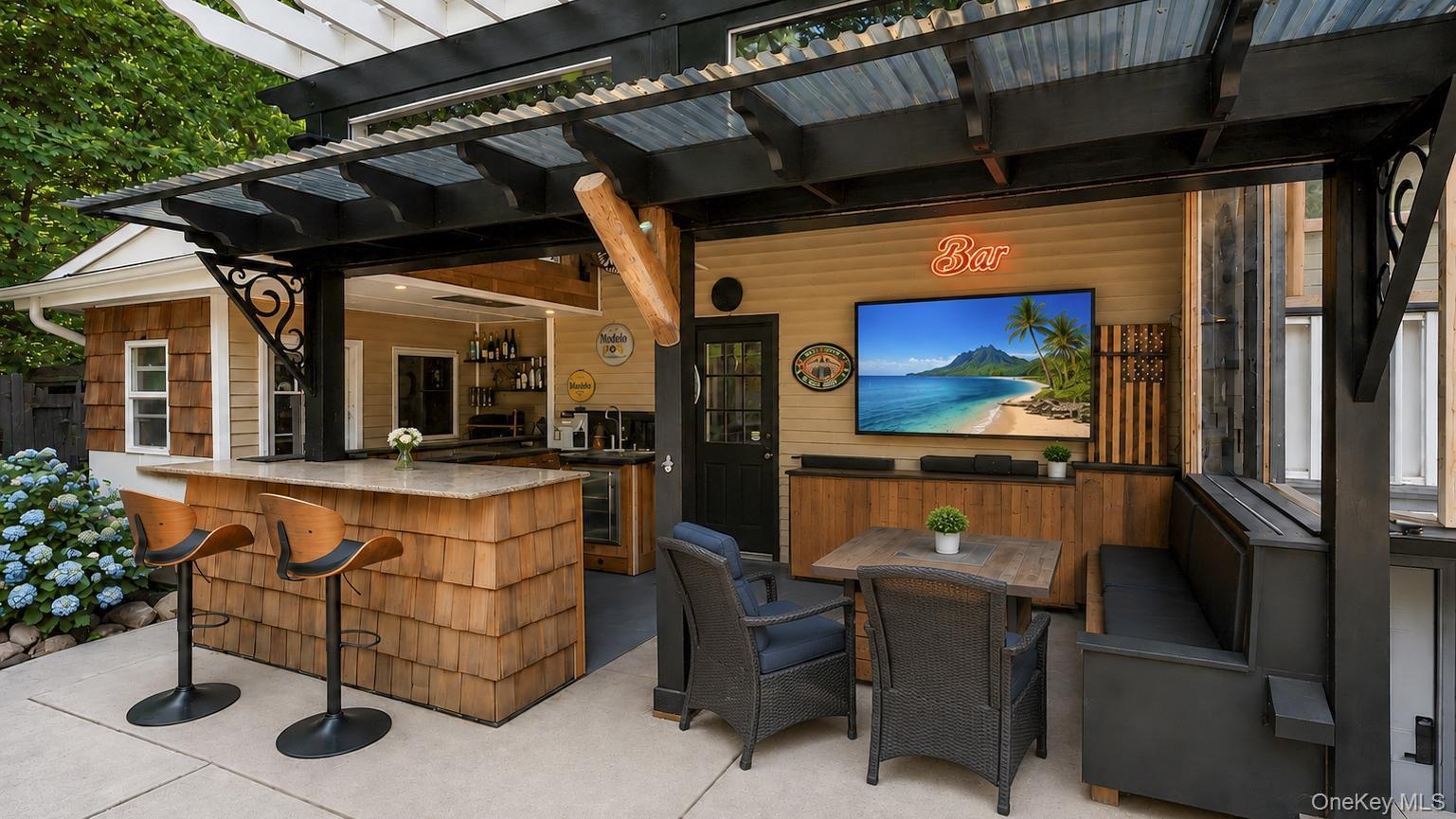 Outdoor entertainment area featuring a corrugated metal roof, wood shake bar with a stone countertop, built-in media console with television, exterior