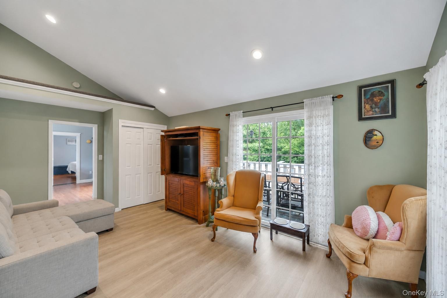 Vaulted ceilings with recessed lighting over wood-finish flooring