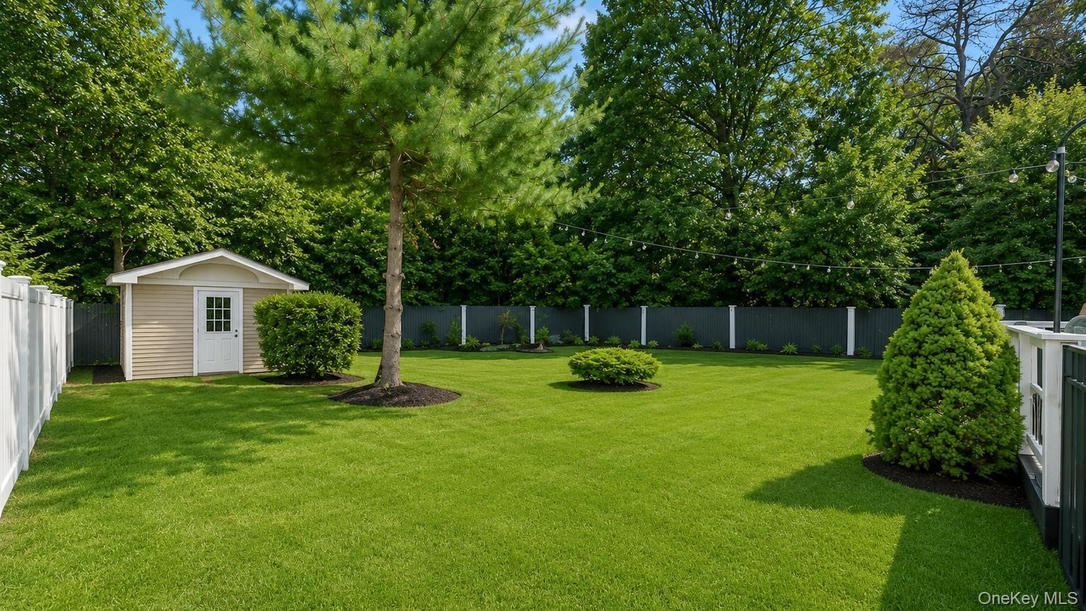 Expansive green lawn featuring a storage shed with siding, white trim, and a paneled door