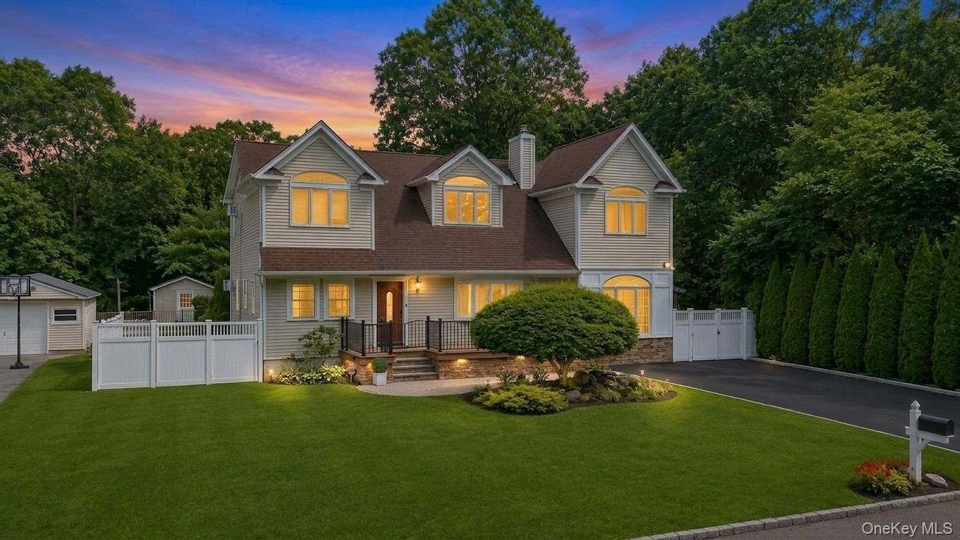 Light-colored siding exterior with a brown shingle roof, stone veneer accents, and dormer windows