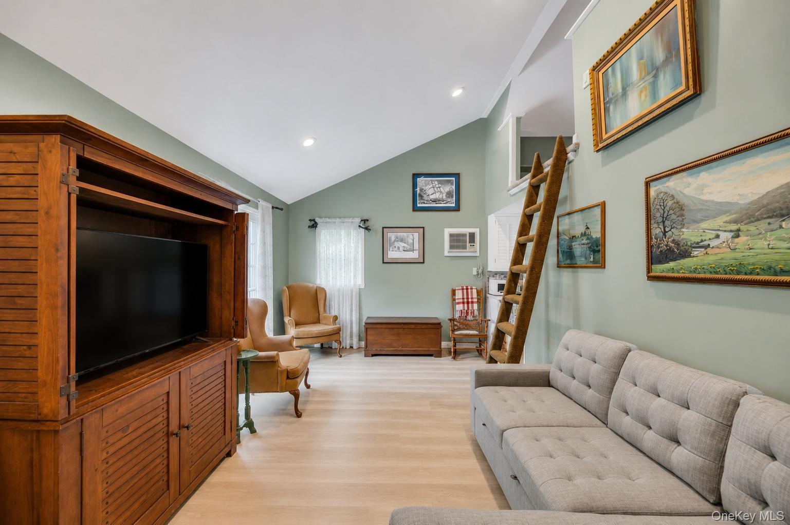 Vaulted ceilings defining a spacious living area with light wood-finish flooring