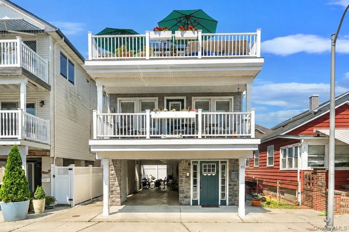 Beautifully maintained elevated home with covered parking and multiple outdoor living spaces.