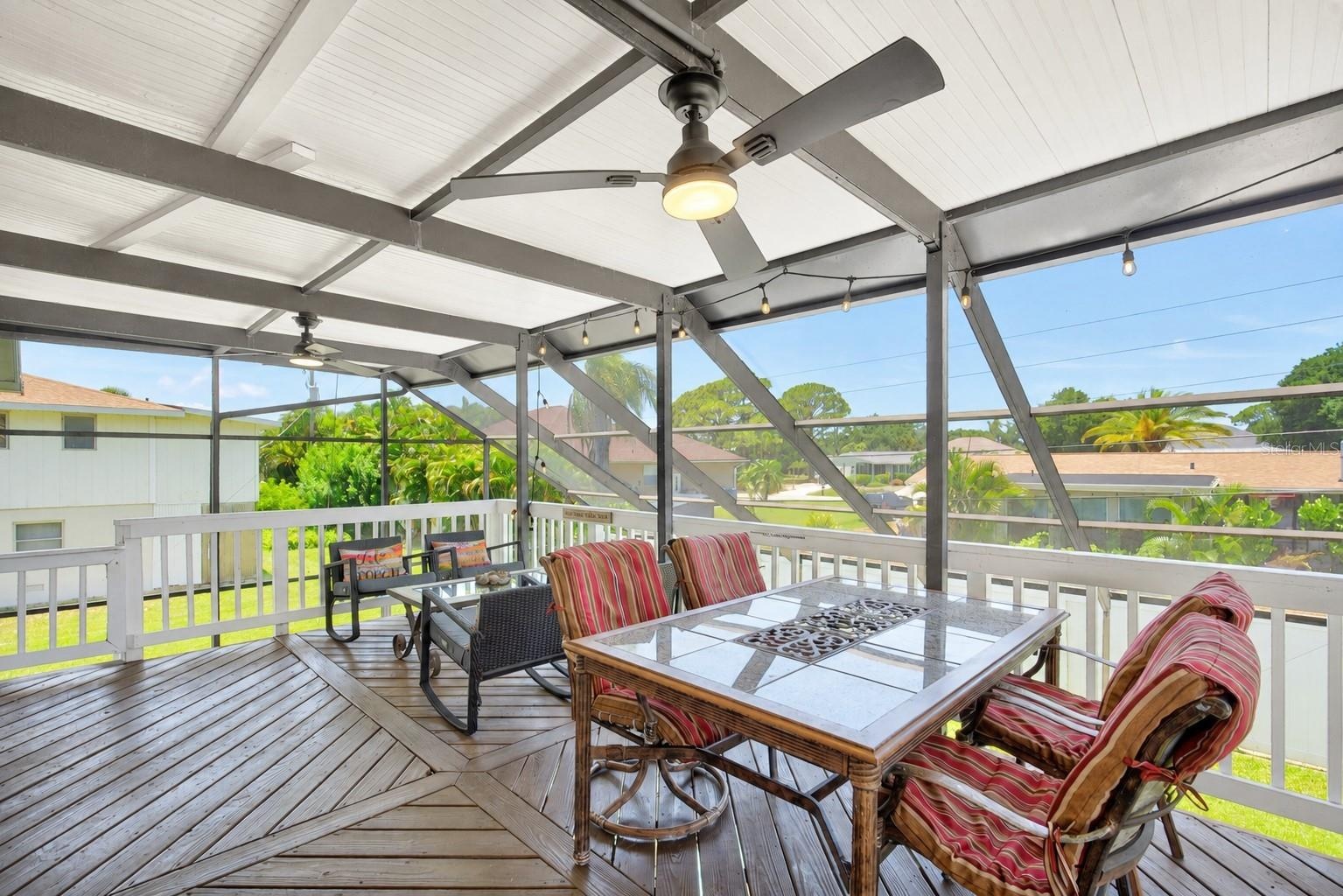 Large covered deck with stairs to pool.
