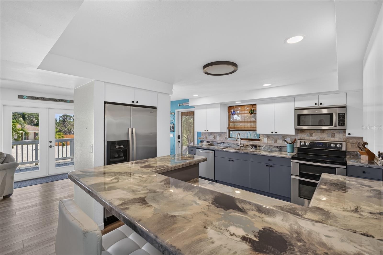 pdated kitchen featuring epoxy countertops, stainless steel appliances, and ample cabinetry.