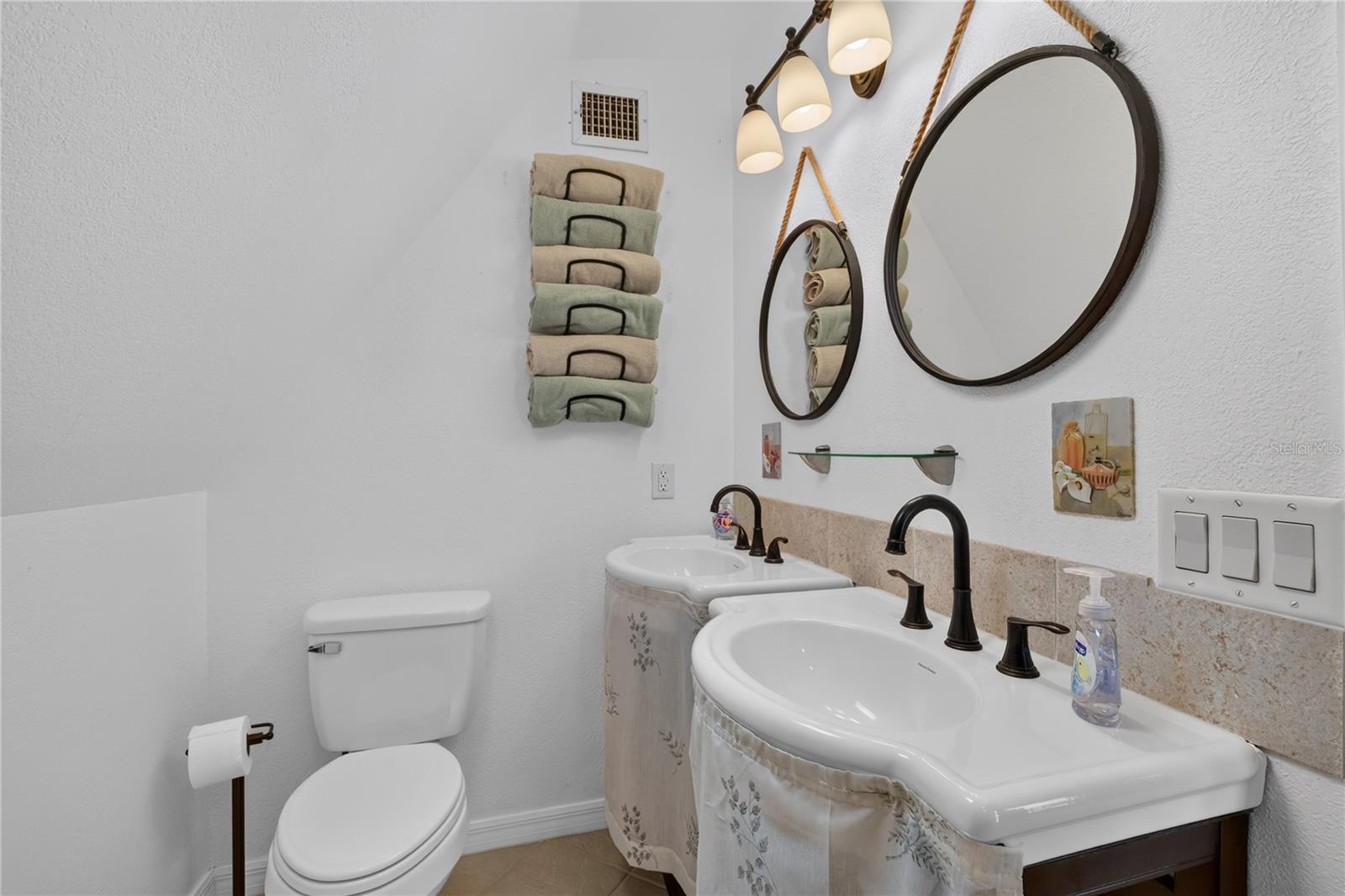 Primary bathroom with modern vanities, decorative mirrors, and stylish fixtures.