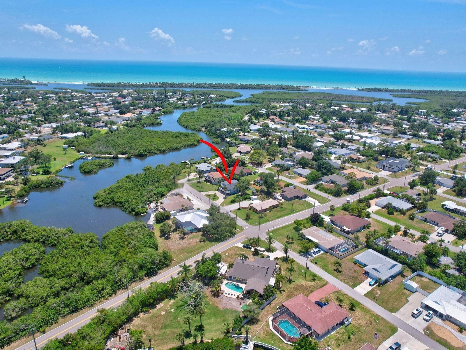Elevated drone view showing the home's proximity to waterways and the Gulf Coast.