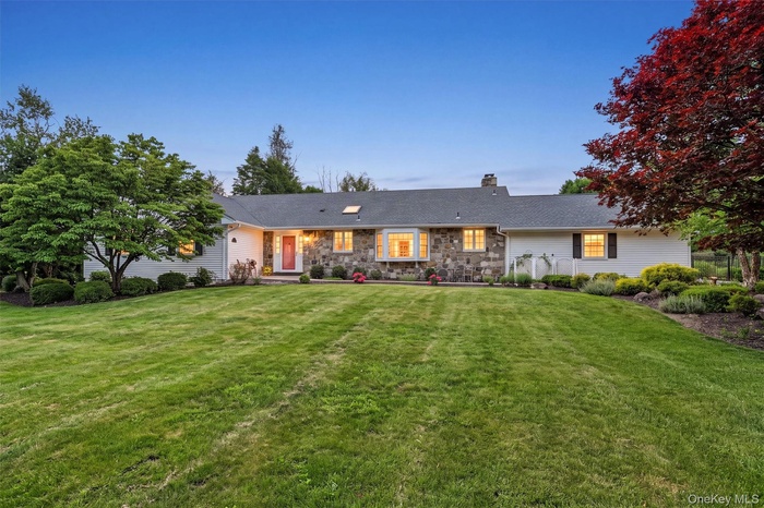 A warm twilight view of 5 Hedges Road, a beautifully maintained Warwick ranch where pride of ownership is evident from the moment you arrive.