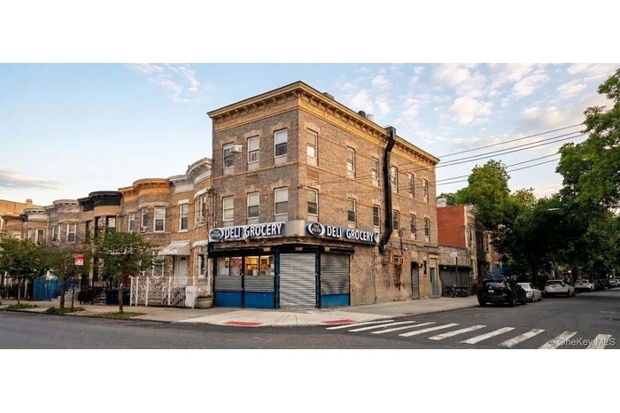 Corner commercial building featuring a brick exterior and ground-floor retail space