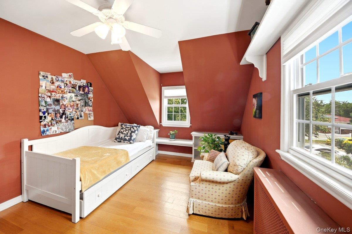2nd floor Bedroom featuring sloped ceilings, hardwood flooring, and multiple windows