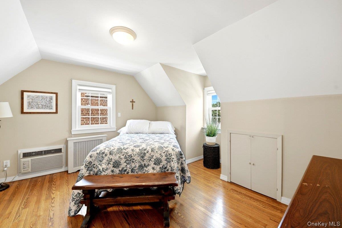 Hardwood flooring and sloped ceilings define this 2nd floor bedroom