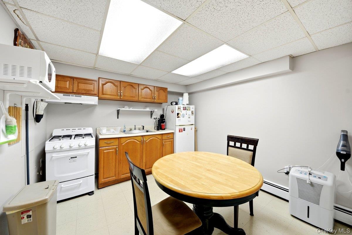 Kitchenette featuring wood cabinetry, a gas range, a sink with a countertop