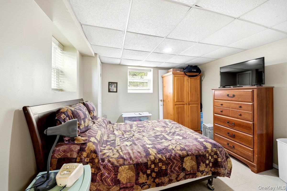Lower-level room featuring light-toned walls, & two windows