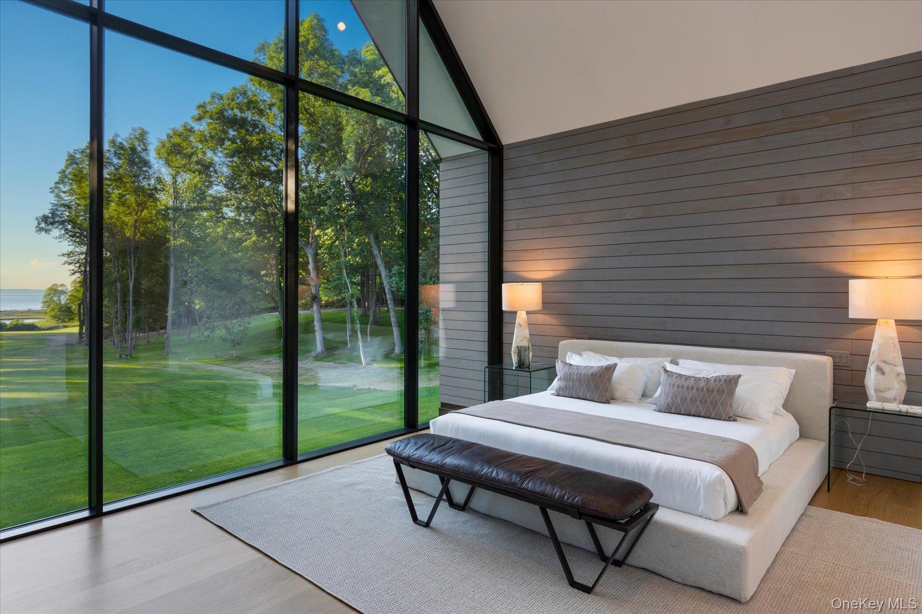 Second floor primary bedroom with stunning floor to ceiling windows and water views with en suite bath and expansive walk in closet