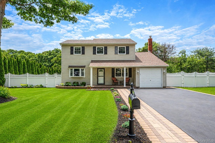 Stunning Colonial featuring a covered front porch with recessed lighting, oversized driveway; attached one car garage.