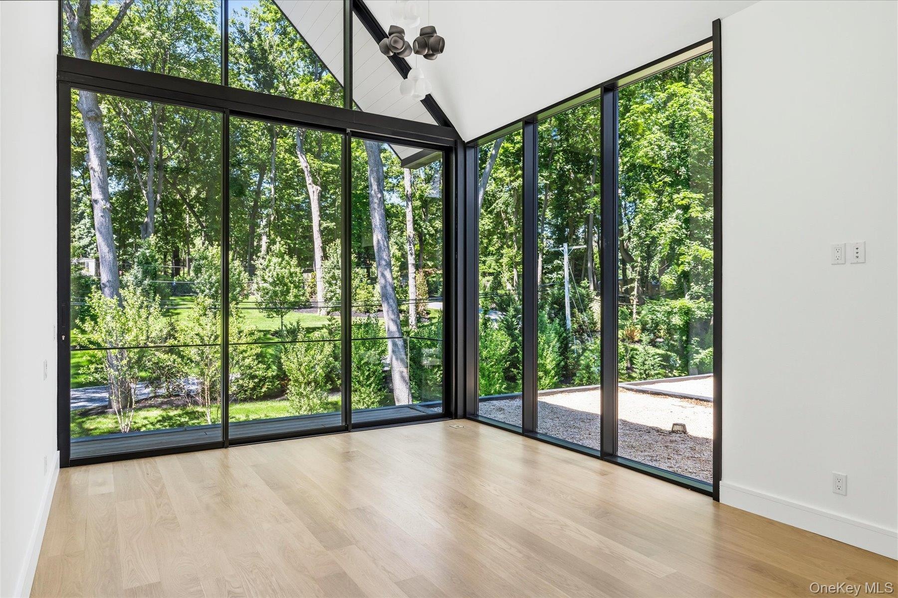 Second floor bedroom with floor to ceiling windows and outdoor access to balcony with water views