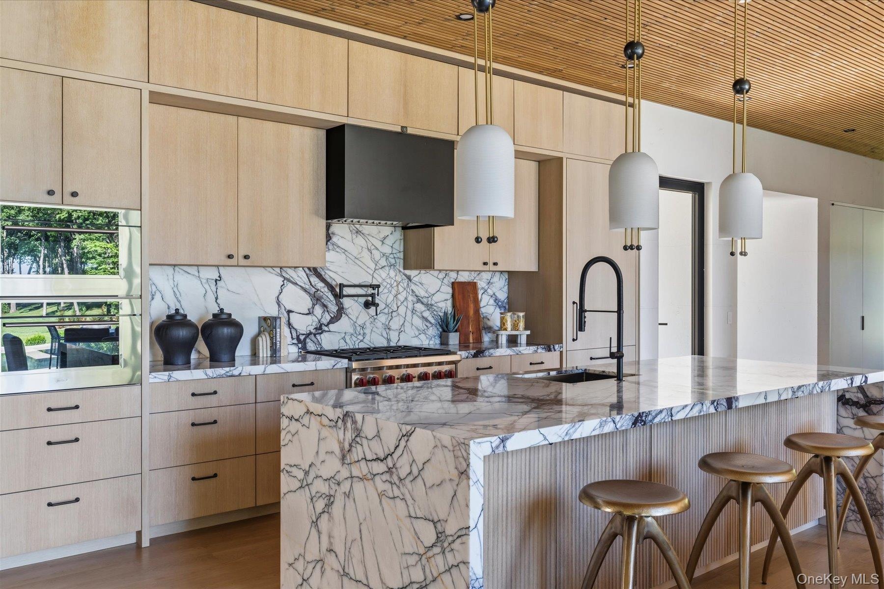 Chef’s kitchen with oversized lilac marble island and custom cabinetry