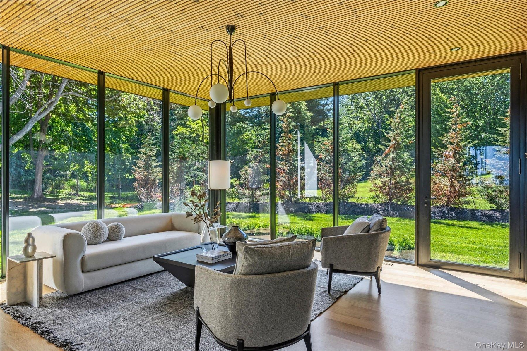 Den with floor to ceiling windows and custom built-ins and outdoor access.