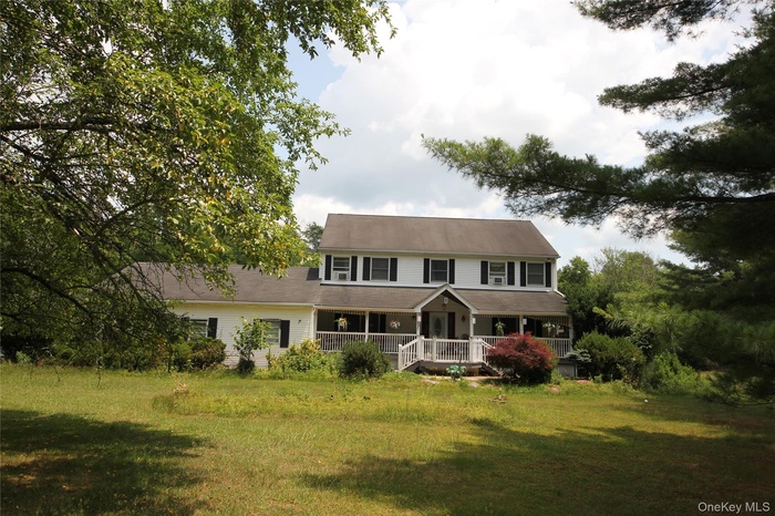 Two-story residence featuring white siding and dark shutters