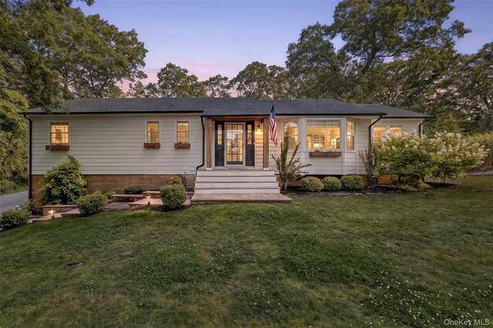 Ranch-style residence featuring white siding and a dark shingle roof