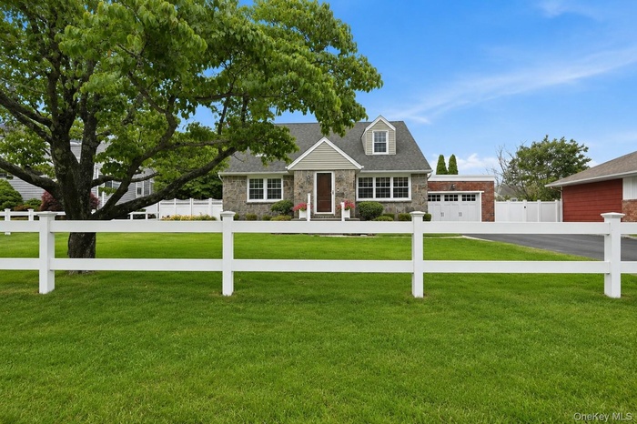 Picket fence, stone facade and enclosed portico add to the beauty of this well manicured property